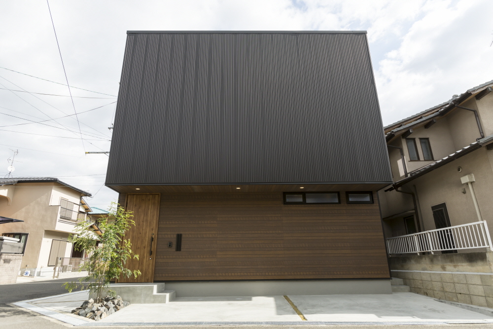 落ち着いた外観で、<br>吹き抜けからたくさんの陽が降り注ぐ2階建て